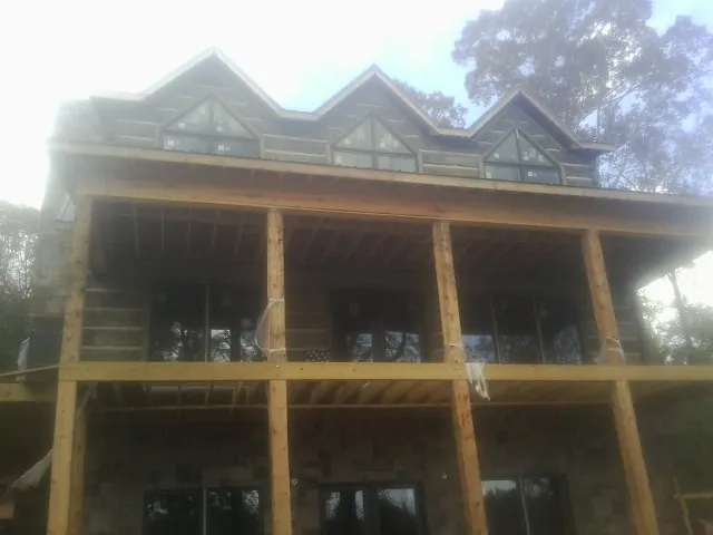 Dormers and porch framing on a large log home under construction — Roof Coating work by our crew in Lebanon